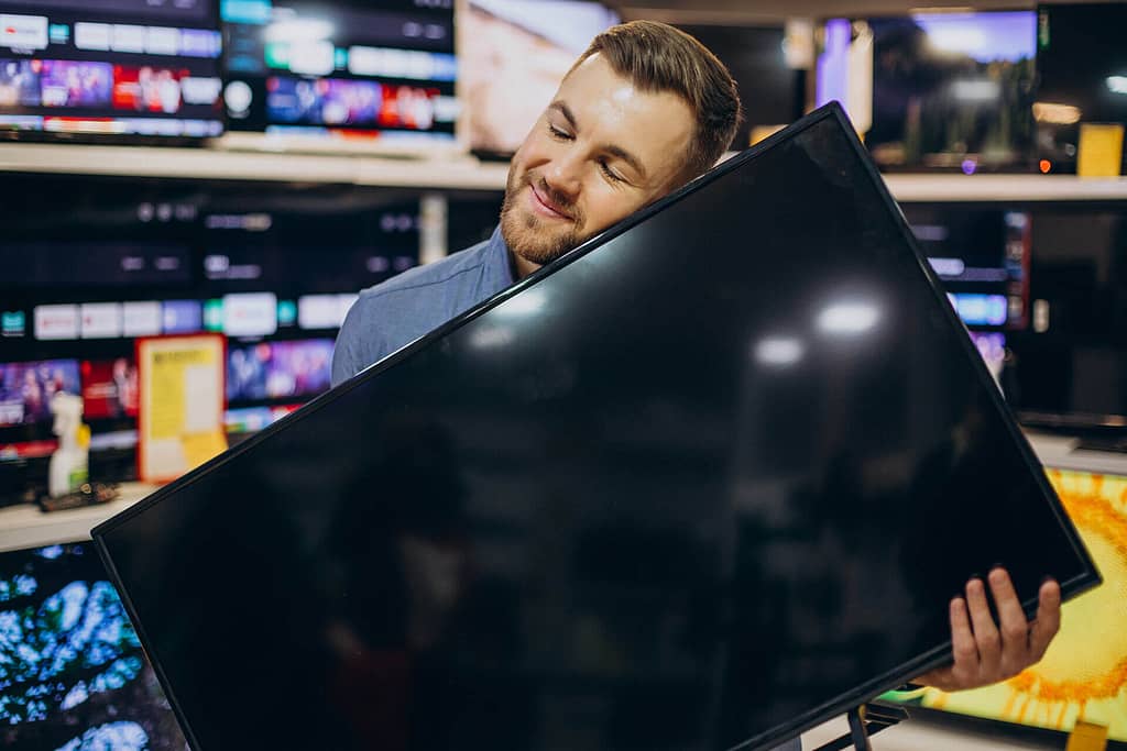 A man hugging a tv for some reason